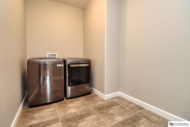 washroom with washer and dryer, baseboards, and laundry area