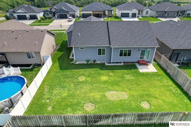 back of property featuring a garage, a residential view, and a fenced backyard