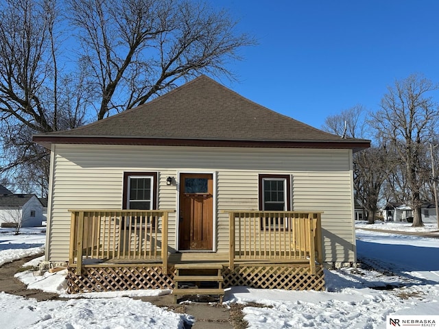 view of front of house featuring a wooden deck and a shingled roof