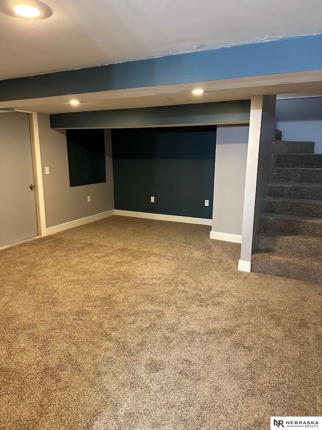 finished basement featuring carpet flooring, stairs, and baseboards