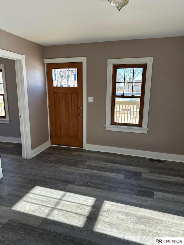 foyer entrance featuring visible vents, baseboards, and a wealth of natural light