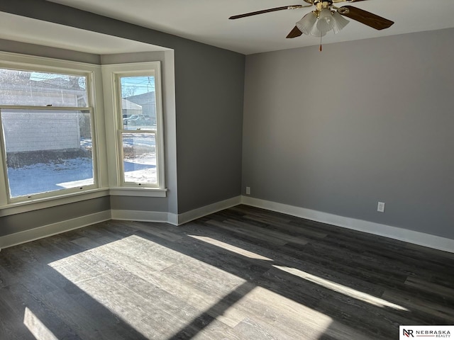 unfurnished room featuring dark wood finished floors, baseboards, and ceiling fan