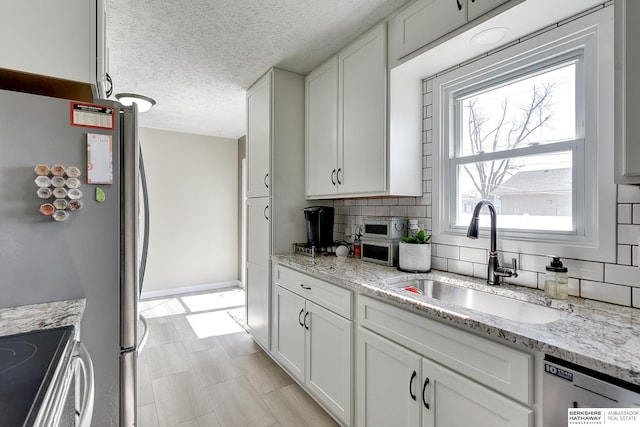 kitchen featuring a sink, appliances with stainless steel finishes, and white cabinets