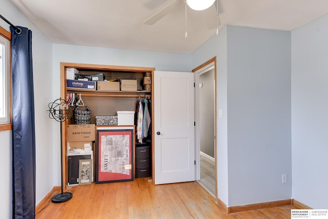 interior space featuring ceiling fan, a closet, baseboards, and wood finished floors