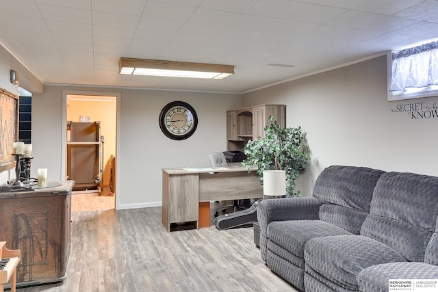 office space with baseboards, ornamental molding, and light wood finished floors