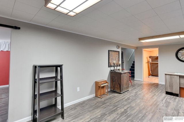 interior space with visible vents, baseboards, stairway, a barn door, and wood finished floors