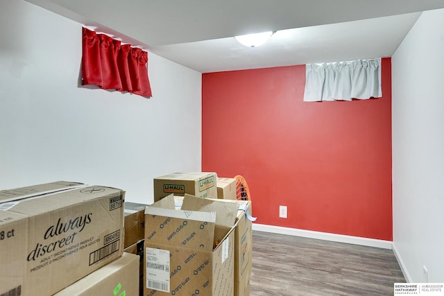 interior space featuring baseboards and wood finished floors