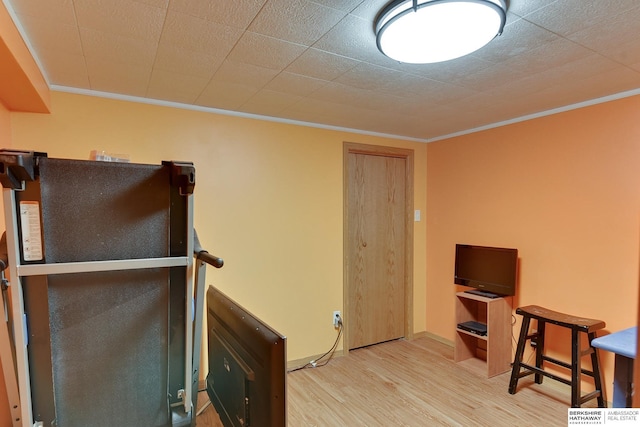 interior space with wood finished floors, baseboards, and ornamental molding