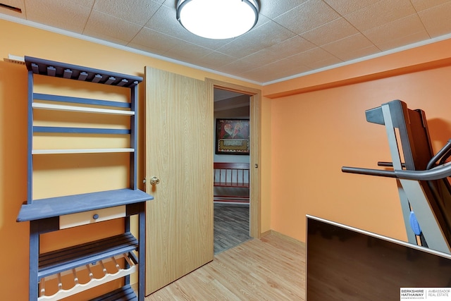 interior space featuring wood finished floors, visible vents, and ornamental molding