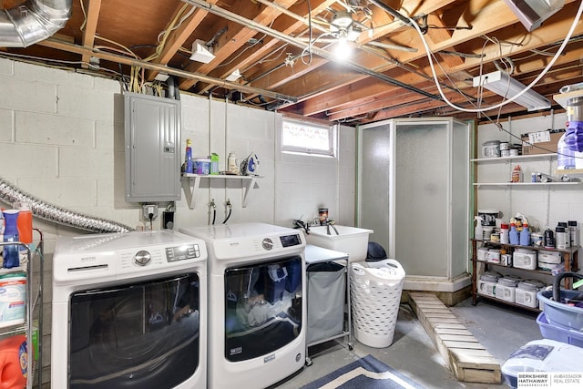 clothes washing area featuring electric panel, laundry area, washing machine and dryer, and a sink