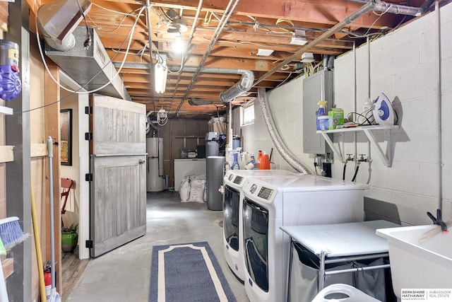 laundry area featuring independent washer and dryer, electric panel, a sink, water heater, and laundry area