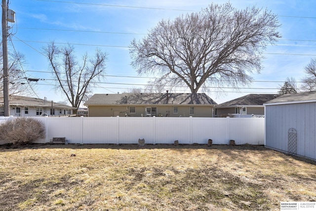 view of yard featuring a storage unit, fence private yard, and an outdoor structure