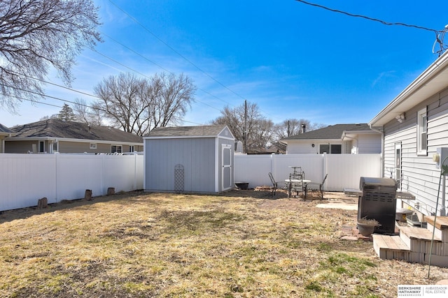 view of yard with an outbuilding, a fenced backyard, and a shed