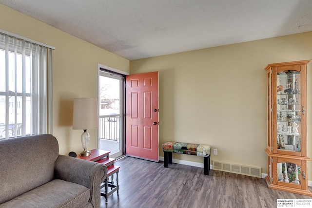 sitting room with visible vents, plenty of natural light, and wood finished floors