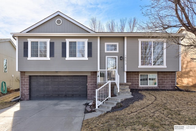 bi-level home with concrete driveway and an attached garage