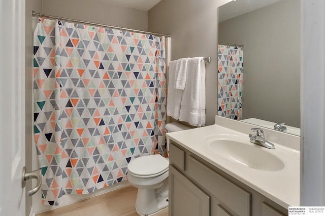 full bathroom featuring a shower with shower curtain, toilet, wood finished floors, and vanity