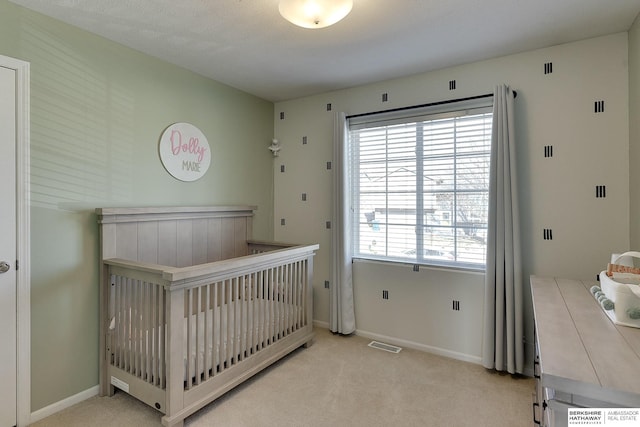 bedroom featuring baseboards, visible vents, and light carpet