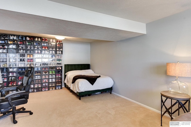 bedroom with baseboards, a textured ceiling, and carpet