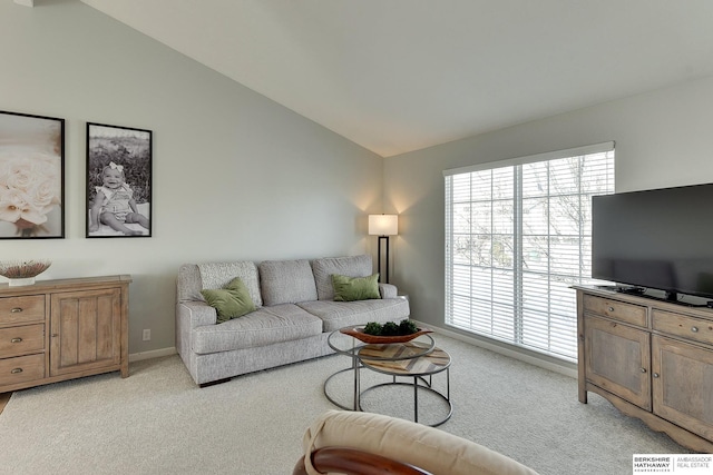 living area featuring light colored carpet, baseboards, and vaulted ceiling