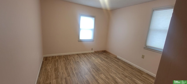 unfurnished room featuring baseboards and wood finished floors