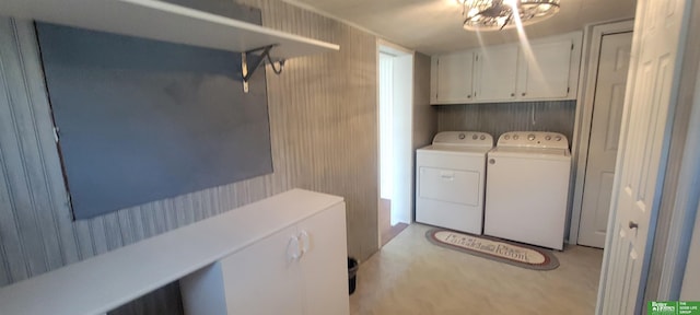 washroom featuring cabinet space and washer and clothes dryer