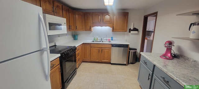 kitchen featuring washer / dryer, white appliances, light countertops, and a sink