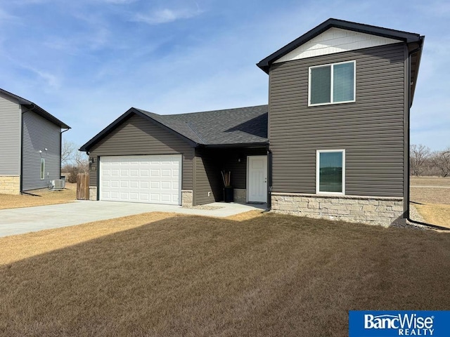 view of front of house with central air condition unit, a front lawn, roof with shingles, concrete driveway, and a garage