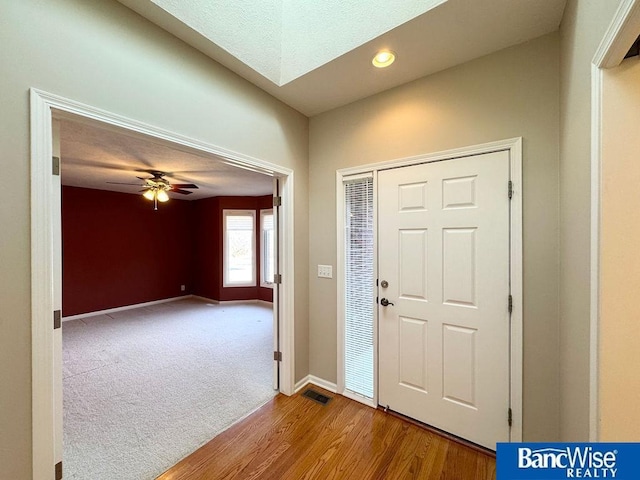 carpeted entrance foyer with wood finished floors, visible vents, baseboards, recessed lighting, and ceiling fan