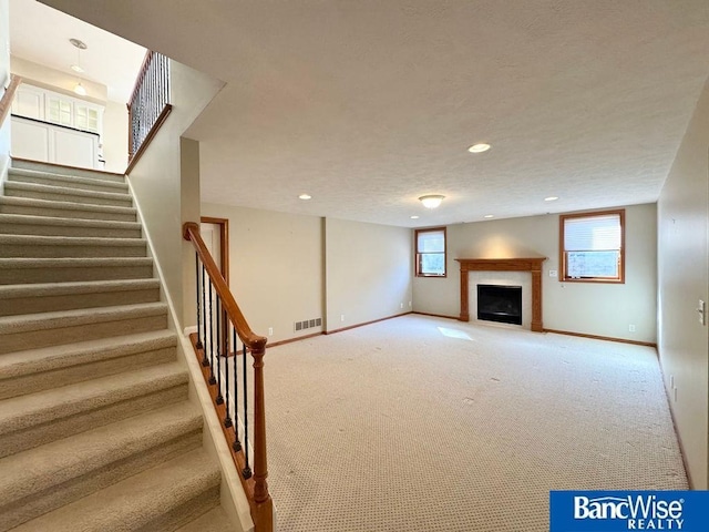 basement with visible vents, carpet flooring, stairway, and baseboards