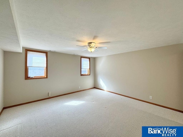 carpeted empty room with baseboards, a textured ceiling, and a ceiling fan