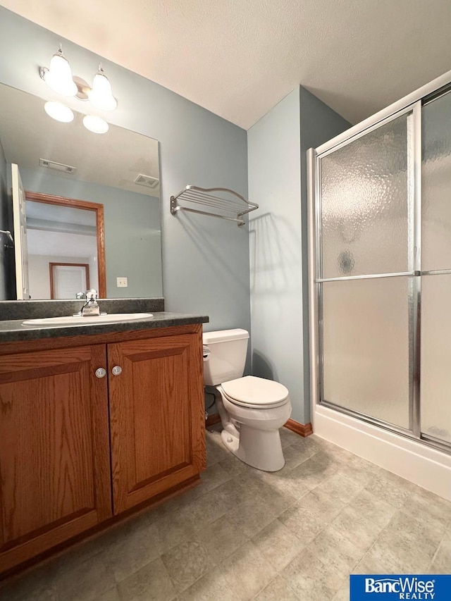 full bathroom featuring vanity, a shower stall, toilet, and visible vents