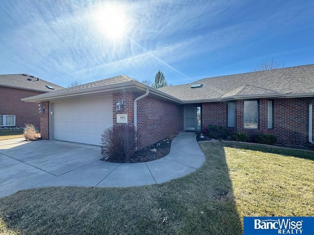 ranch-style house with driveway, a front lawn, an attached garage, a shingled roof, and brick siding