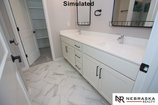 full bath featuring a sink, a spacious closet, marble finish floor, and double vanity