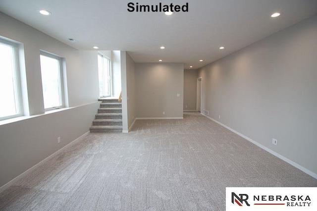 below grade area featuring light carpet, recessed lighting, stairs, and baseboards