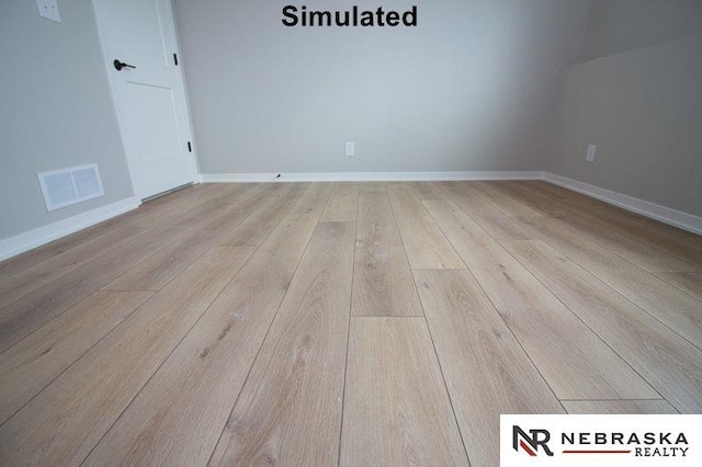 unfurnished room featuring baseboards, visible vents, and wood-type flooring