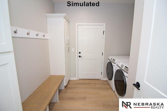 laundry area with washer and dryer, light wood-style flooring, and cabinet space