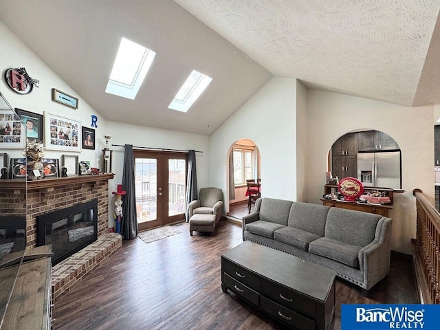 living room with french doors, dark wood-type flooring, a fireplace, and a textured ceiling