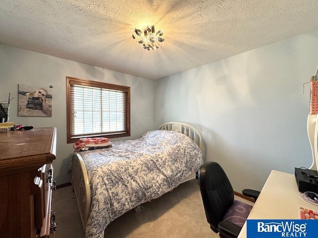 carpeted bedroom featuring baseboards and a textured ceiling