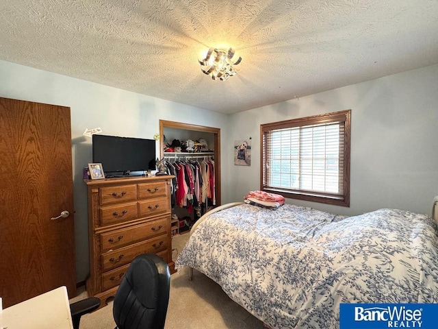 bedroom with a closet, a textured ceiling, and carpet