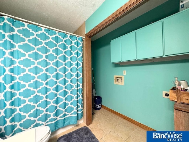 bathroom featuring baseboards, a textured ceiling, curtained shower, tile patterned floors, and toilet