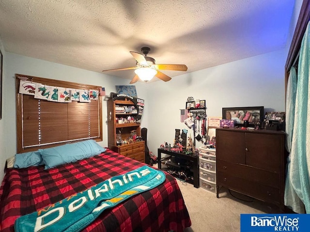 bedroom featuring a ceiling fan, a textured ceiling, and carpet flooring