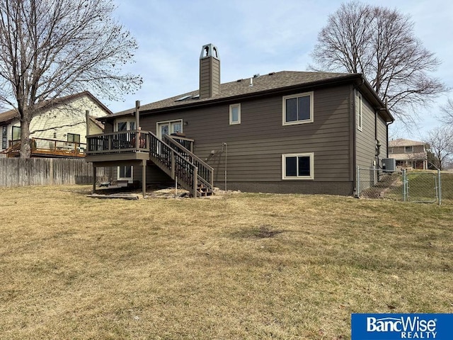 back of house featuring a yard, a chimney, stairs, and fence