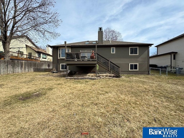 rear view of house with a fenced backyard, a yard, stairway, a wooden deck, and a chimney