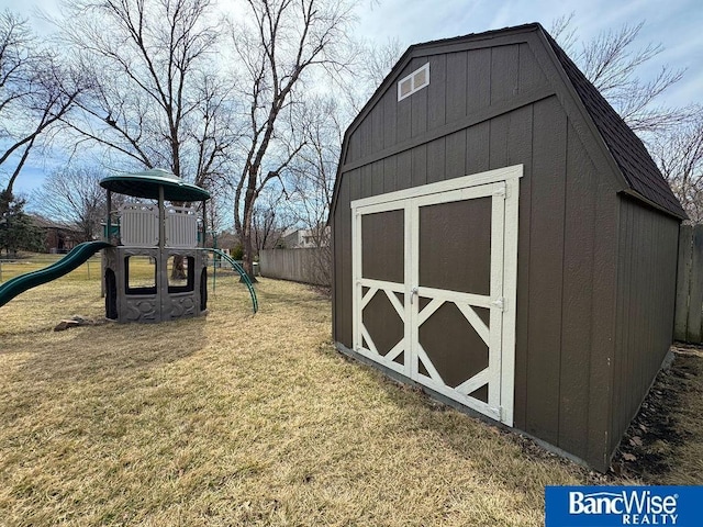 view of shed with a playground and fence