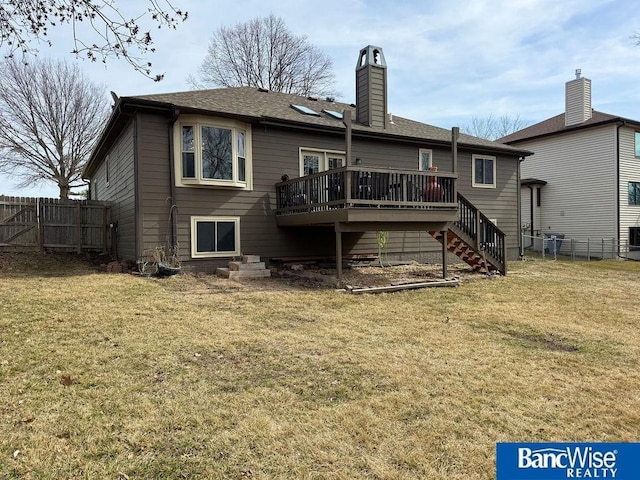 back of property featuring stairway, a lawn, a deck, and fence