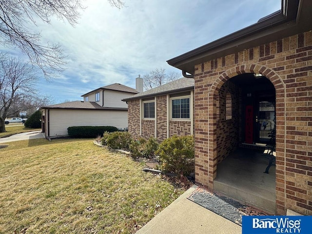 exterior space with brick siding and a lawn