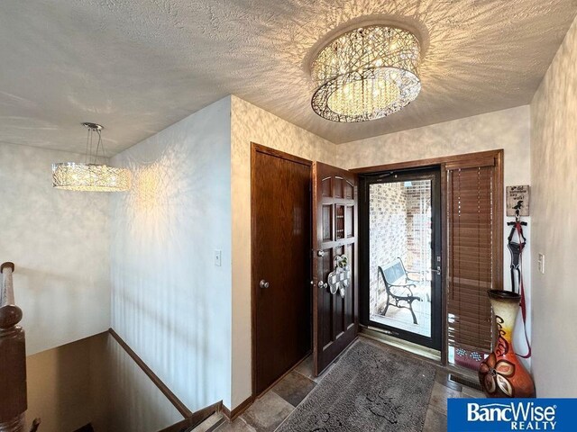 foyer entrance featuring a notable chandelier and a textured ceiling