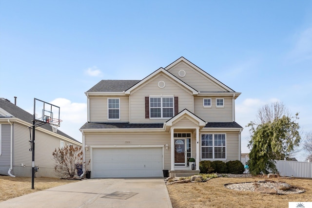 traditional home with concrete driveway, fence, a garage, and a shingled roof