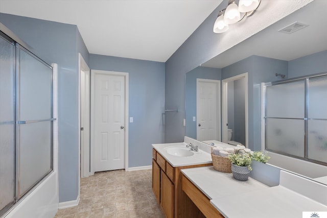 full bathroom featuring visible vents, baseboards, toilet, combined bath / shower with glass door, and vanity