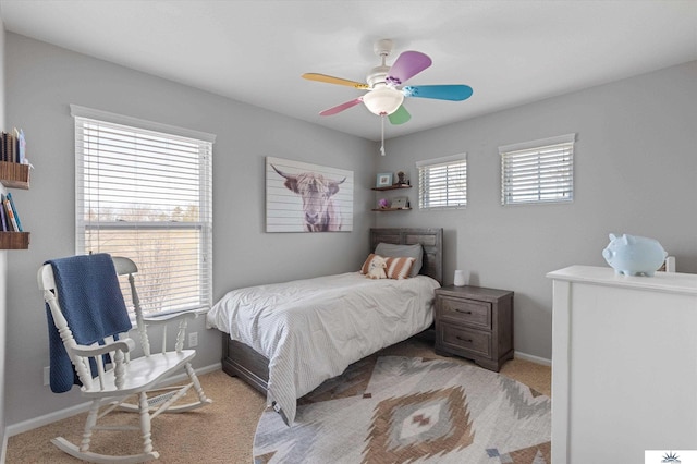 bedroom featuring baseboards, light colored carpet, and a ceiling fan